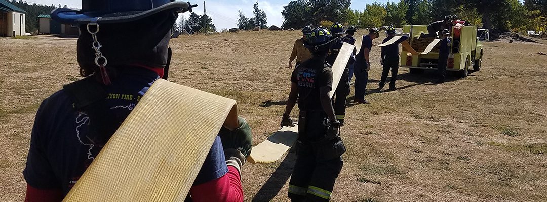 Firefighters loading hose